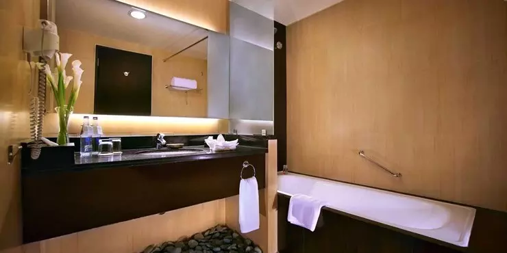 A nicely appointed bathroom with bathtub and shower in a modern stylish classy hotel in kuta bali